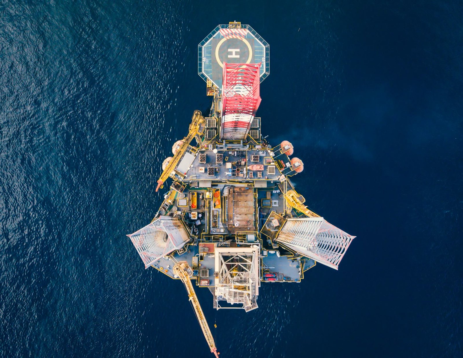A top-down aerial view of an offshore platform at sea.