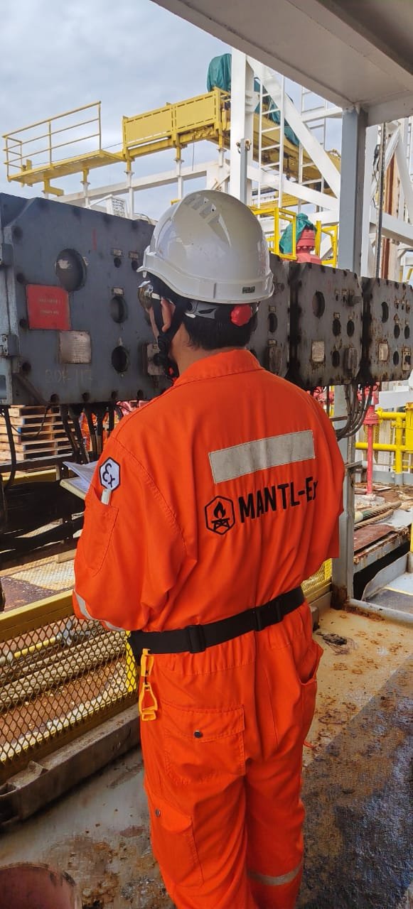 A Mantl-Ex engineer in branded coveralls carrying out an Ex inspection on an offshore platform.
